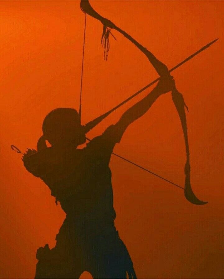 This may contain: the silhouette of a person holding a bow and arrow in front of an orange sky