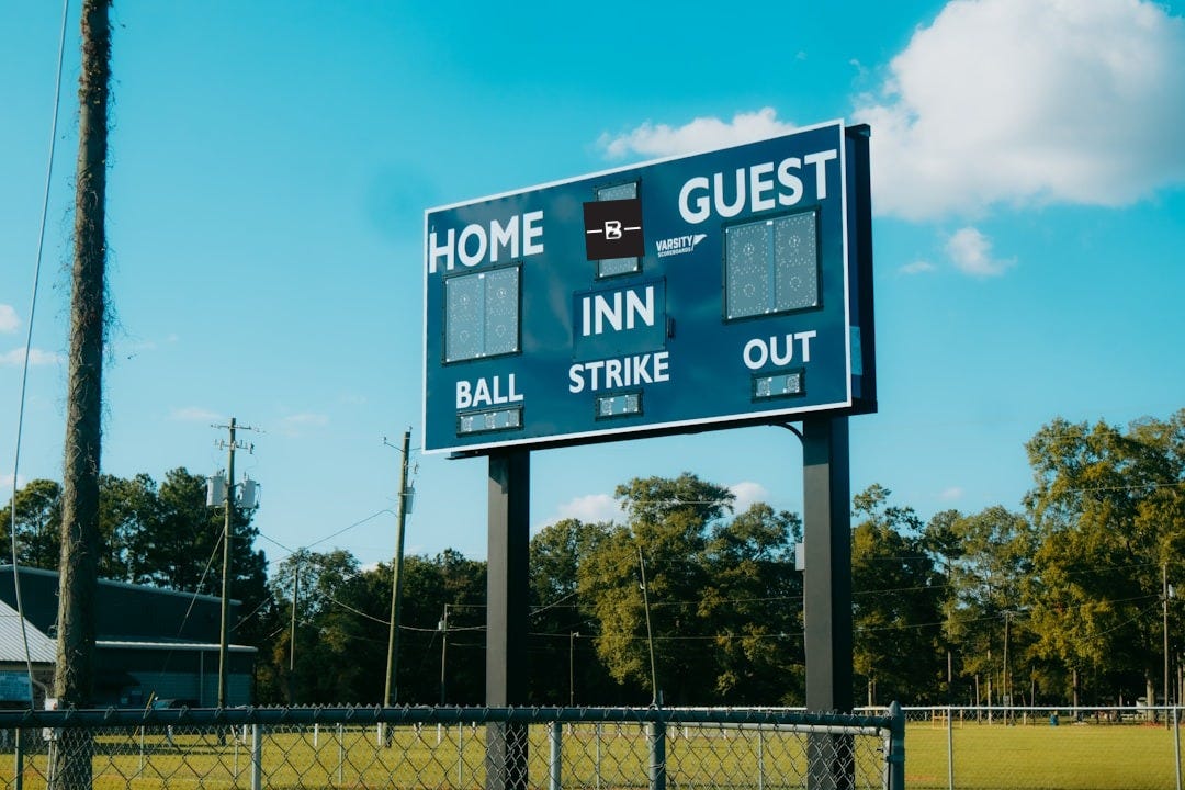 A baseball field with a large sign on it