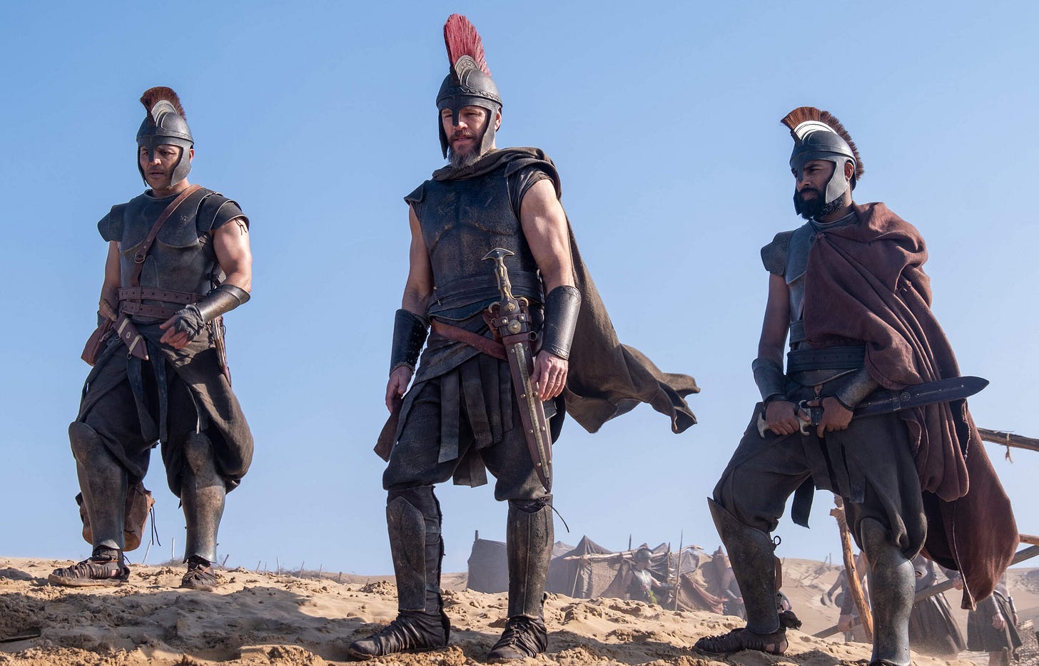 A still from Christopher Nolan's film 'The Odyssey' featuring three Greek soldiers A still from Christopher Nolan's film 'The Odyssey' featuring three Greek soldiers
