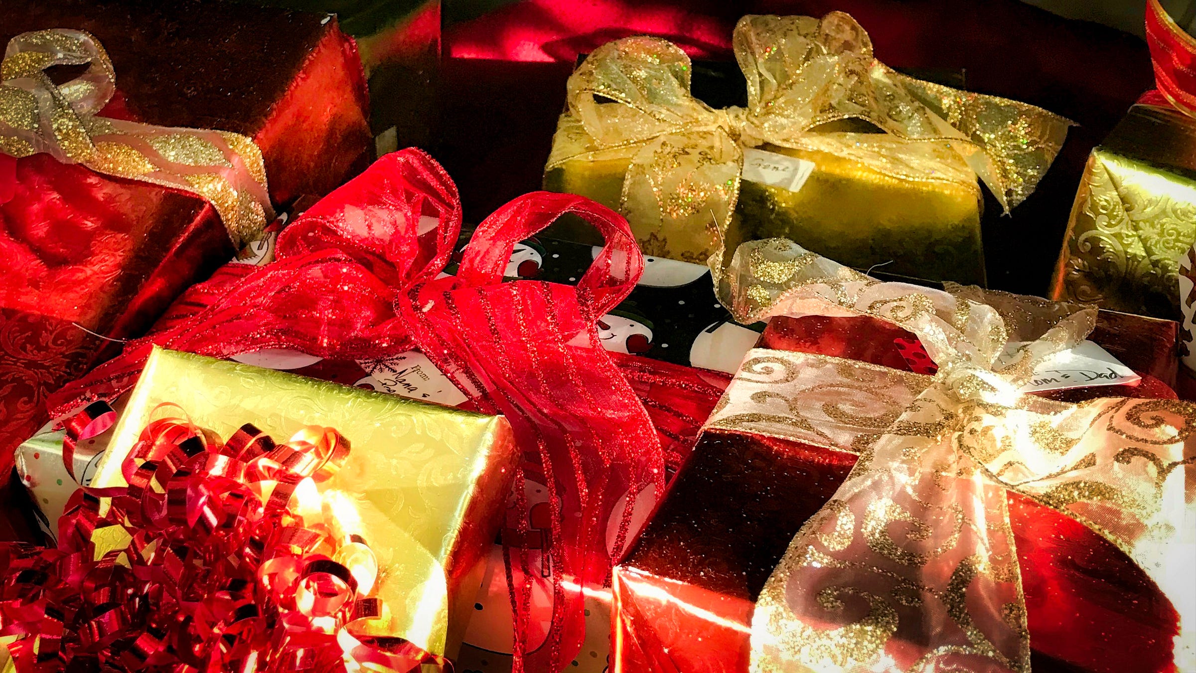 Christmas packages wrapped in red and gold paper with sparkly red and gold bows