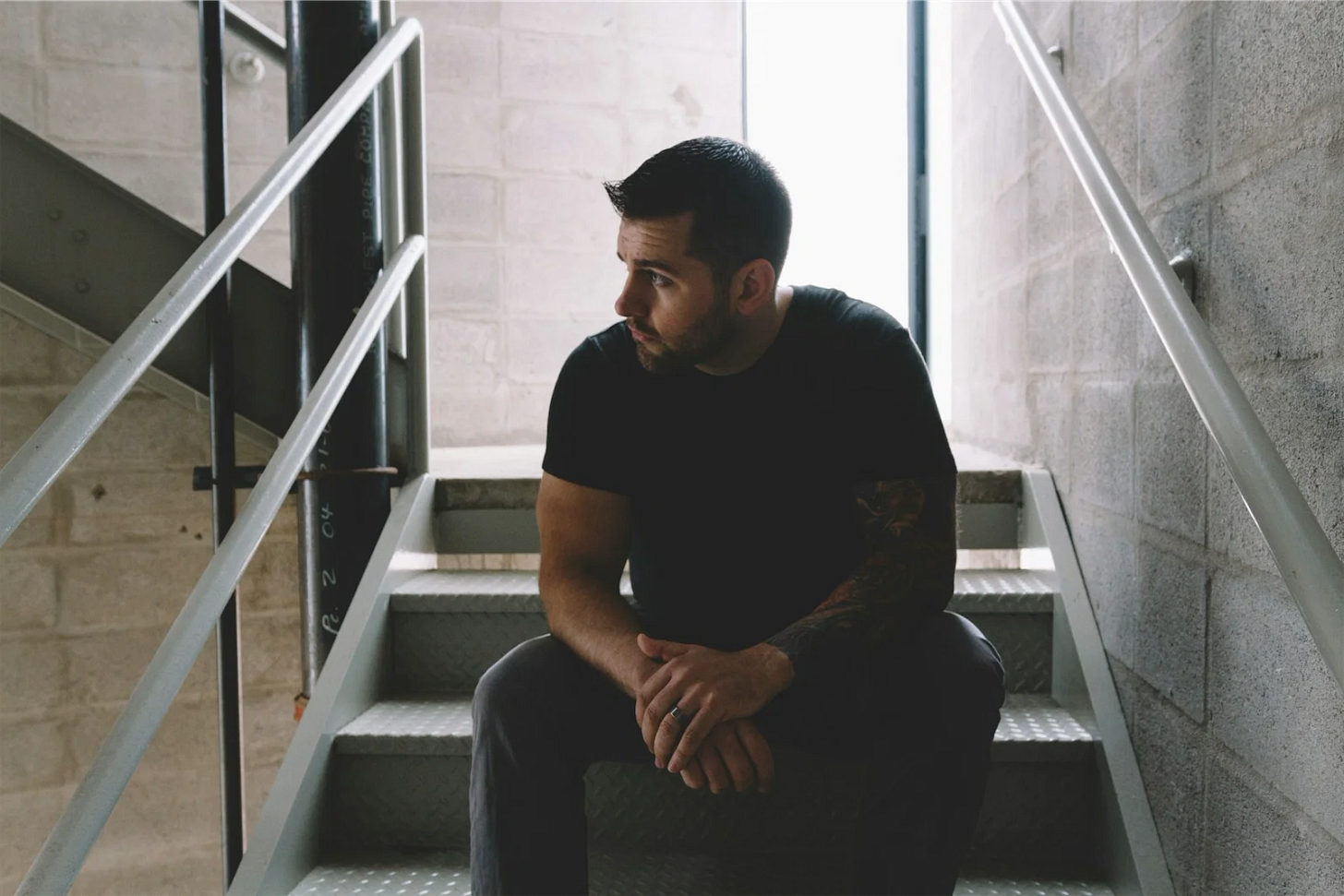 Man sitting alone on a staircase, looking lost and reflective, symbolizing how to find your inner light when life feels too much. Man sitting alone on a staircase, looking lost and reflective, symbolizing how to find your inner light when life feels too much.