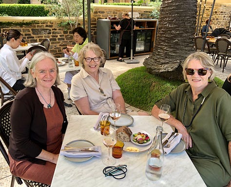 three women having lunch, short woman and tall man, a cheesecake with frosting and easter eggs
