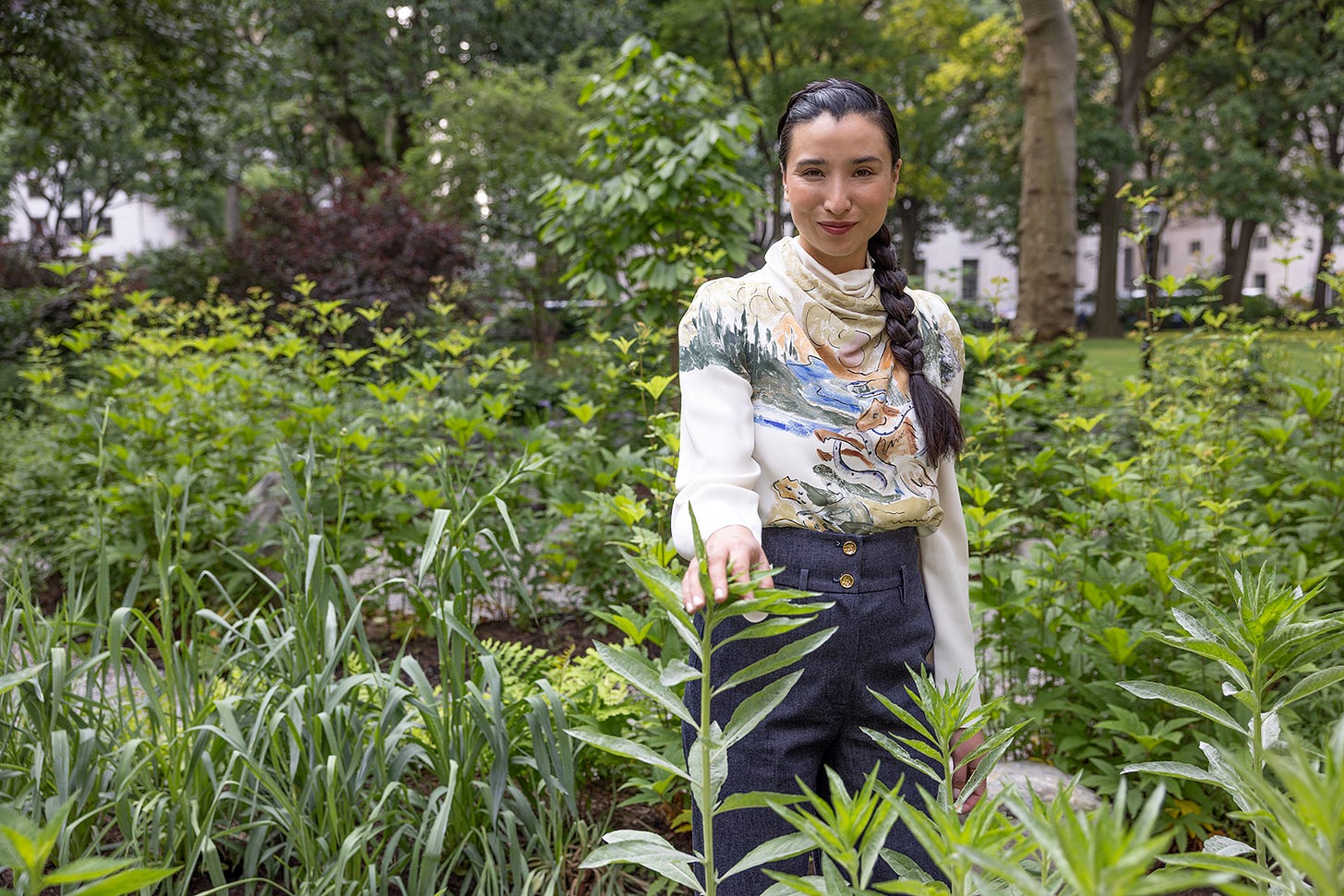 Garden designer Lily Kwong standing in green plants Garden designer Lily Kwong standing in green plants
