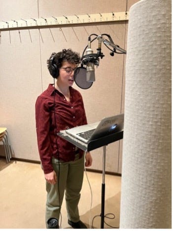 Left image description: Rachel, a femme with curly dark hair and olive skin, stands at a microphone in a studio, reading from a laptop. Right image description: View over an audio control panel and engineer’s microphone into a recording studio where Rachel stands at a microphone.
