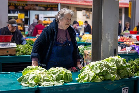 Această galerie se oprește asupra oamenilor din piață: vânzători, legumicultori, femei și bărbați pentru care taraba nu este doar loc de lucru, ci rezultatul unei munci duse luni întregi. Ridurile, privirile, gesturile și răbdarea lor spun o poveste despre efort, continuitate și legătura directă dintre pământ și oraș.
