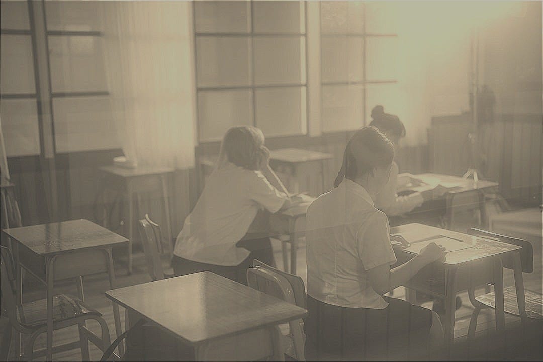 A group of people sitting at desks in a room