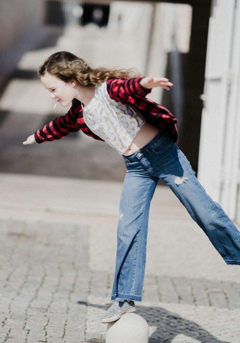 girl balancing on top of concrete stand