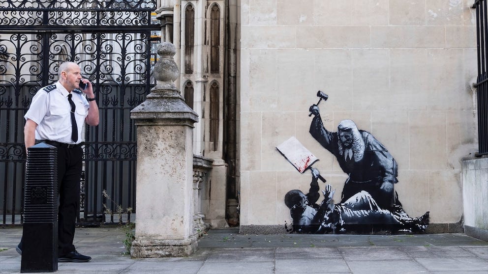 Banksy unveils a new mural of a judge beating a protester outside London  court - ABC News