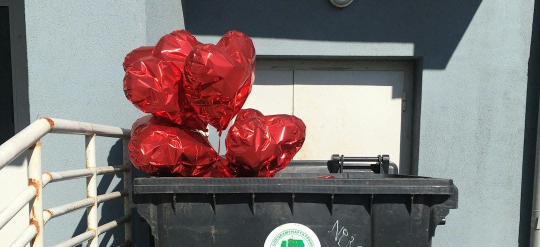 a black trash can with red foil wrapped around it