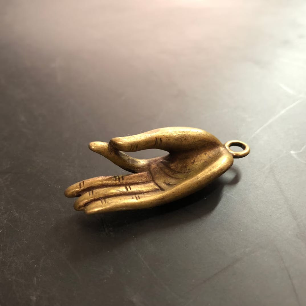 A photo of a mini Buddha hand in a prayer pose.