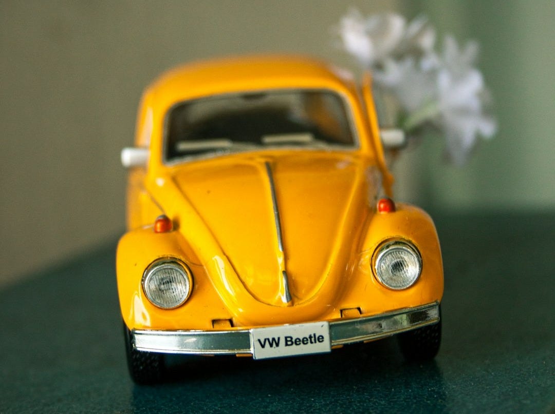 yellow volkswagen beetle on green surface yellow volkswagen beetle on green surface