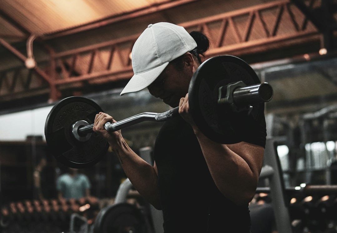 A woman lifting a barbell in a gym