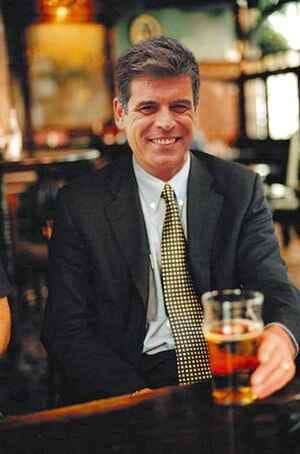 Man in a suit having a beer at an airport bar