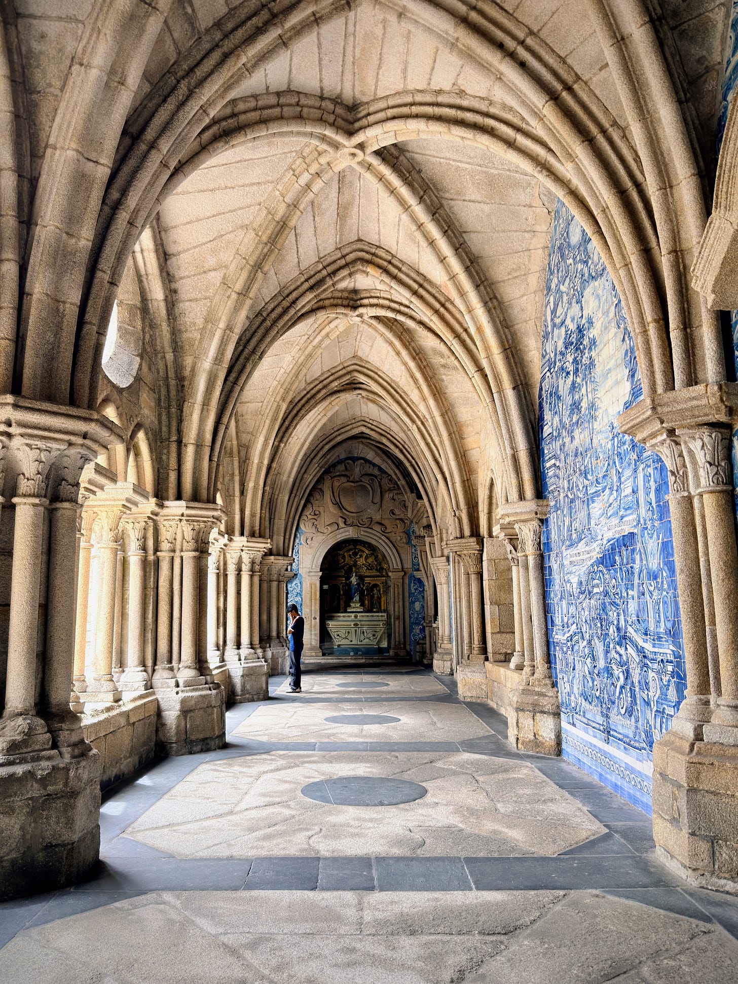 man standing in hallway of cloister walls man standing in hallway of cloister walls