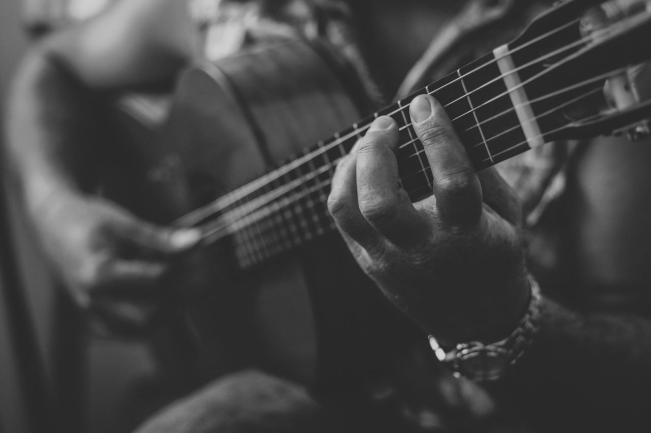Close up of a someone playing a guitar, black and white image Close up of a someone playing a guitar, black and white image