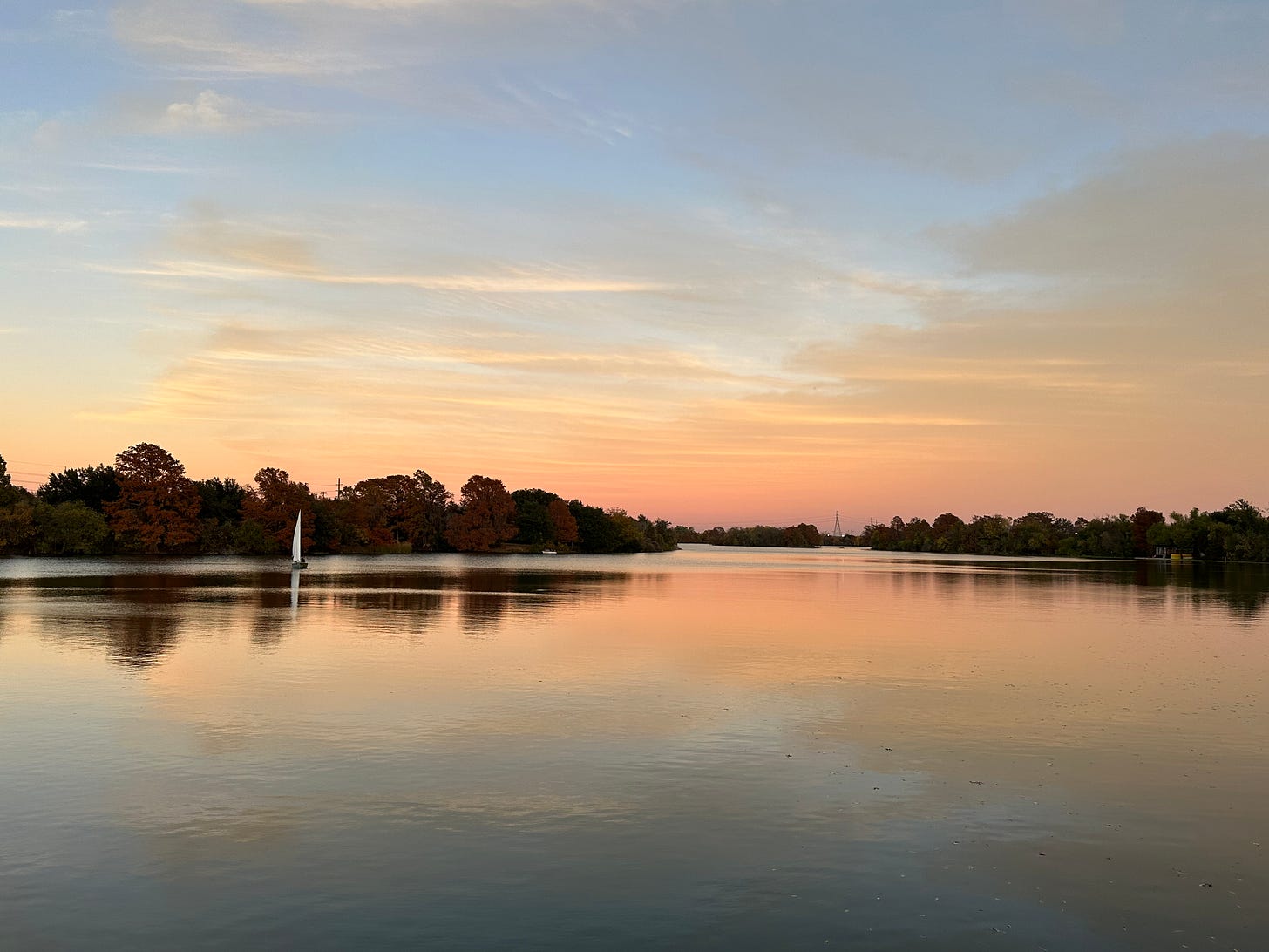The sun sets over a sailboat on Lady Bird Lake in Austin, Texas.