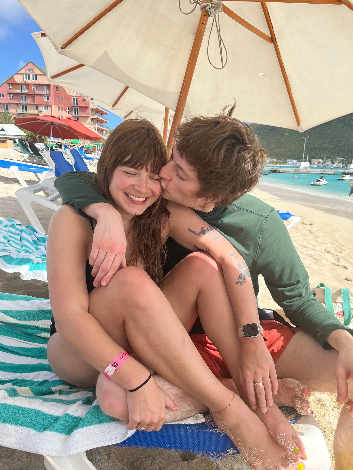 Casey and me on the beach, me kissing her cheek.