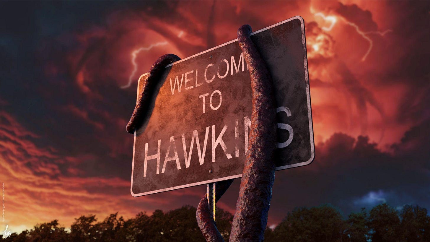 A weathered ‘Welcome to Hawkins’ road sign stands in the foreground at night, partly wrapped by a dark, vine‑like tentacle. Behind it, a looming monster silhouette rises against a glowing red sky, giving the scene an ominous, otherworldly atmosphere.