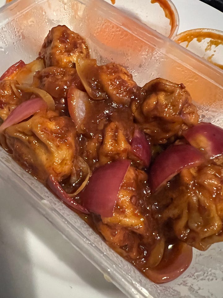 A dish of broken up samosas, topped with sauce, chickpeas, vermicelli, yoghurt & pomegranate seeds plus 3 dishes of different shaped filled dumplings, one with sauce