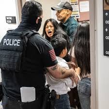 Monica Moreta-Galarza and her children are separated from their husband and father before an ICE agent pushes her into a wall and onto the ground.