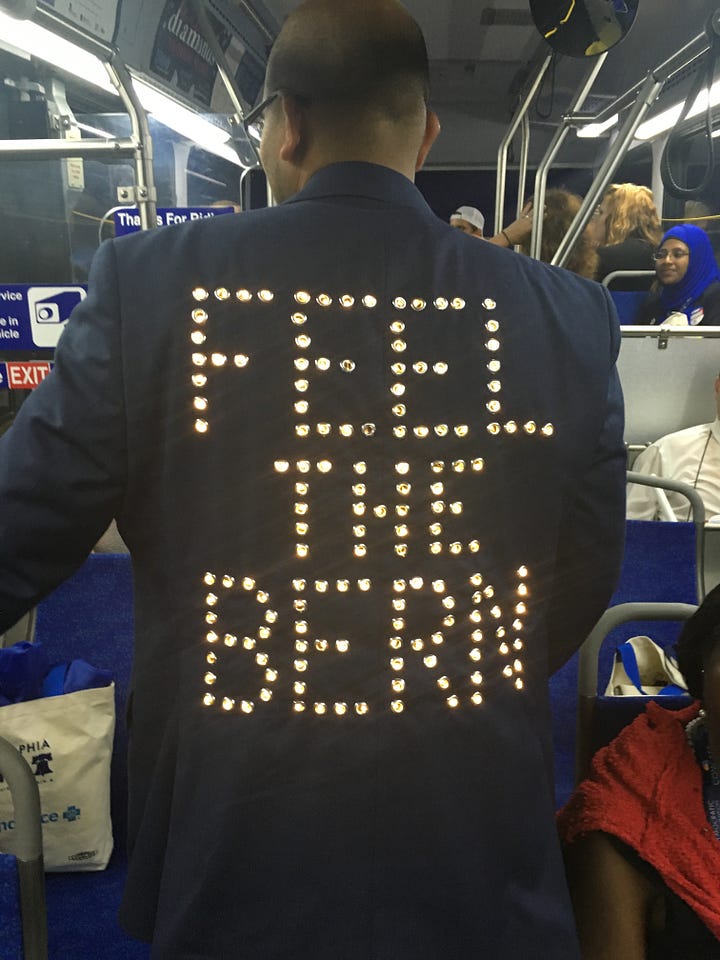 My Journey with Bernie book, DNC 2016, Independence Hall, Green glow-in-the-dark shirts, 2016 DNC Delegate Badge, Delegates, Protestors, and Volunteers in Philadelphia, Lighted FEEL THE BERN Shirt