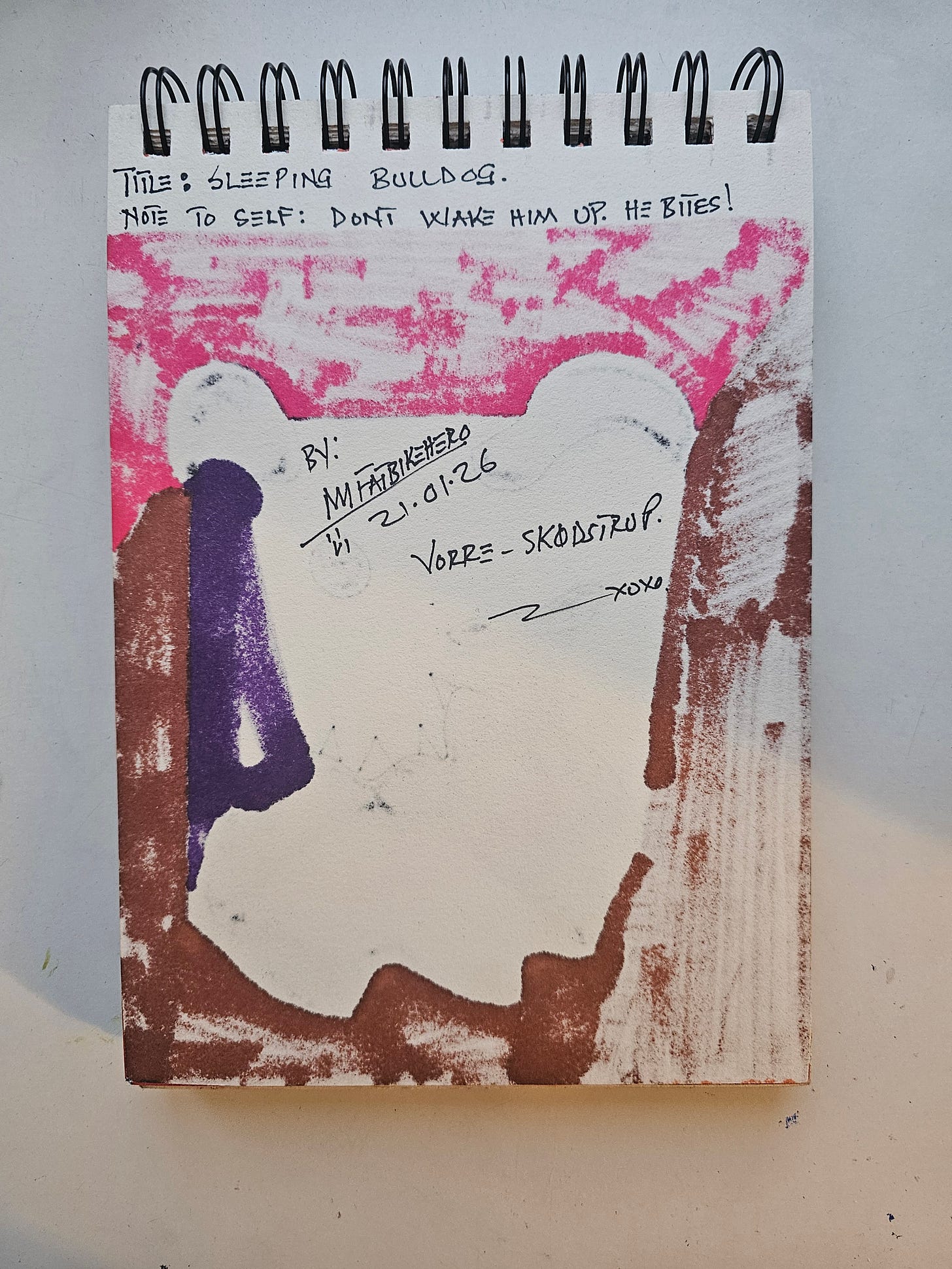 Alt Text: The back of a sketchbook page showing bleed-through markers and handwritten text reading "Title: Sleeping Bulldog. Note to Self: Don't Wake Him Up. He Bites!" signed by FatbikeHero, Vorre-Skodstrup, dated 21.01.26.