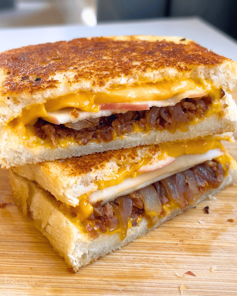 vegan grilled cheese on a cutting board stacked one on top of the other