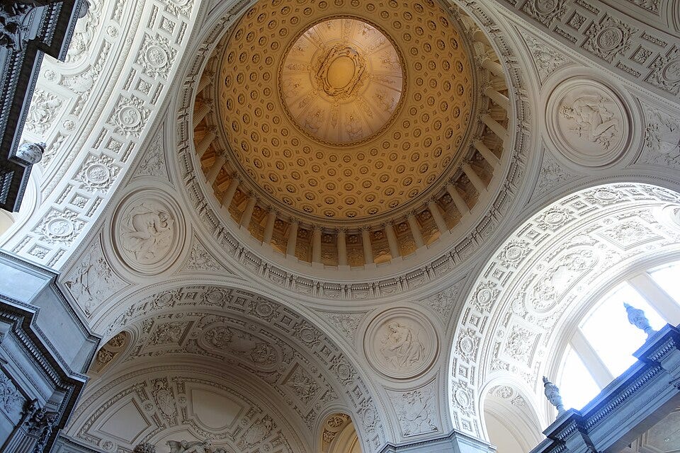 Looking up into the ornate dome of San Francisco City Hall, with gilded details and tiers of arches and columns. Looking up into the ornate dome of San Francisco City Hall, with gilded details and tiers of arches and columns.