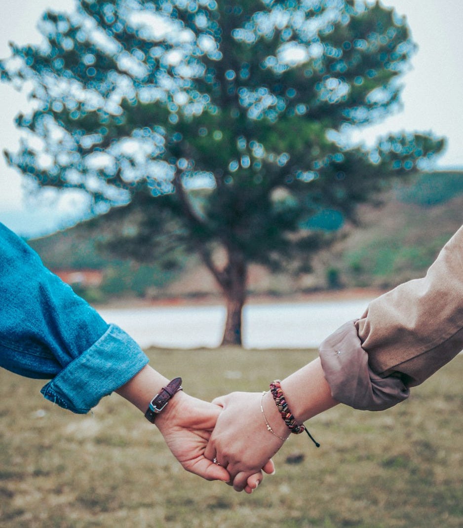 two persons holding hands
