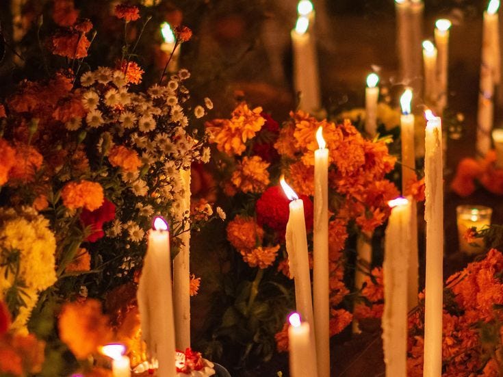 This may contain: many candles are lit in front of flowers This may contain: many candles are lit in front of flowers