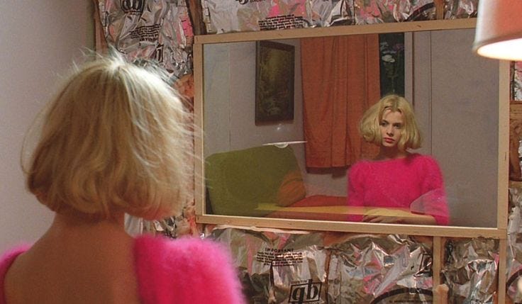 This may contain: a woman looking at herself in the mirror