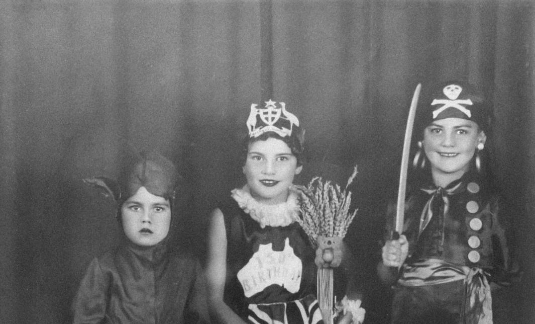a black and white photo of three children in costumes
