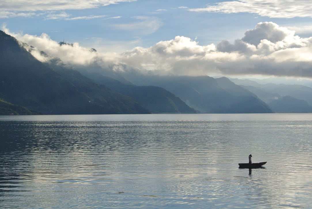 An image of Lake Atitlan, with a man in a boat
