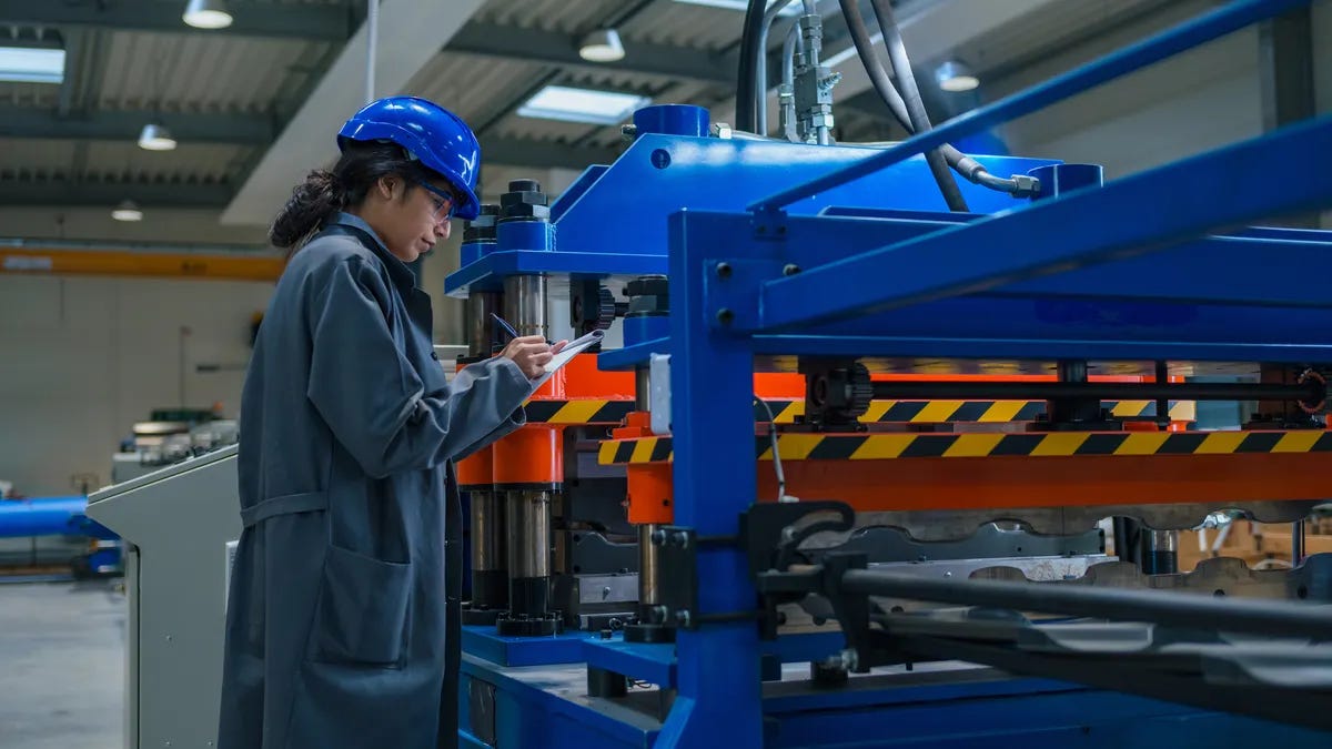 A worker in an industrial setting uses a clipboard. A worker in an industrial setting uses a clipboard.