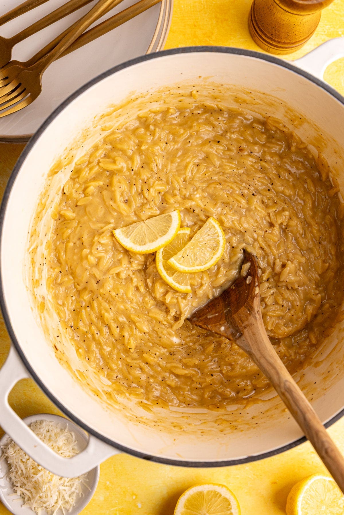 A pot of freshly cooked Creamy Lemon Orzo, topped with a few lemon slices.