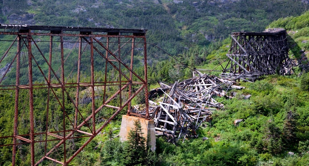 broken bridge high over trees leaving an impassable gap