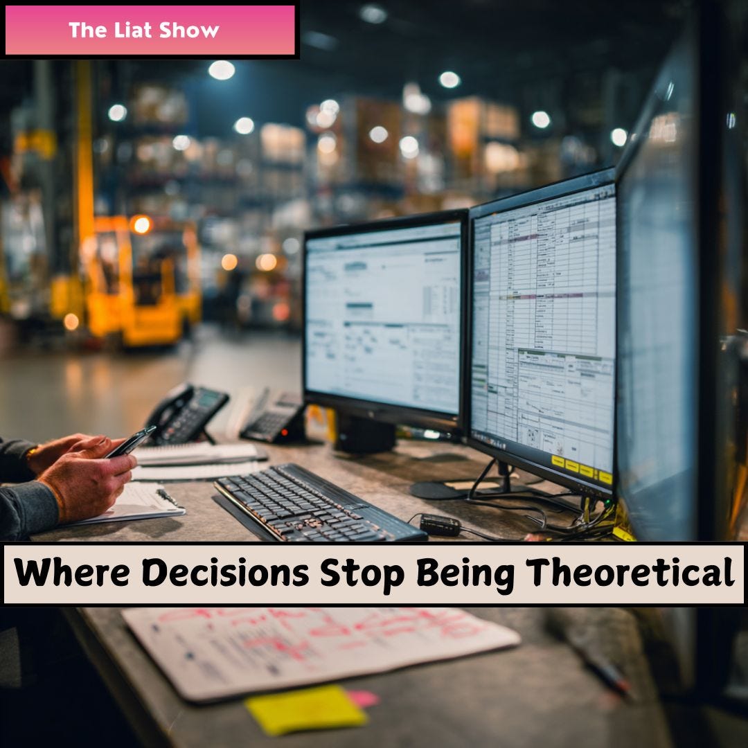 Liat Portal for The Liat Show: Warehouse operations desk during live planning. Liat Portal for The Liat Show: An operations workstation inside a warehouse with dual monitors displaying inventory and planning spreadsheets while a worker holds a phone, capturing the moment where planning outputs collide with real time execution constraints.