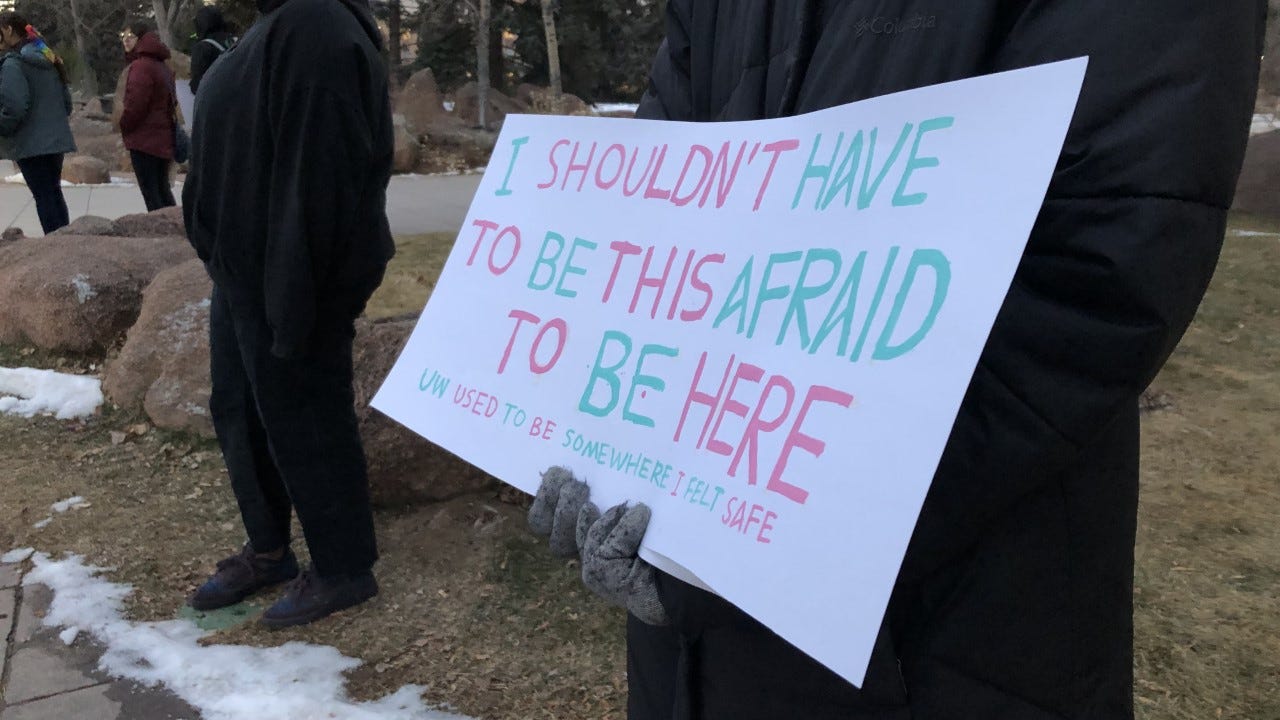 Protestor in black coat, holding sign that reads "I shouldn't have to be this afraid to be here. UW used to be somewhere I felt safe." Protestor in black coat, holding sign that reads "I shouldn't have to be this afraid to be here. UW used to be somewhere I felt safe."