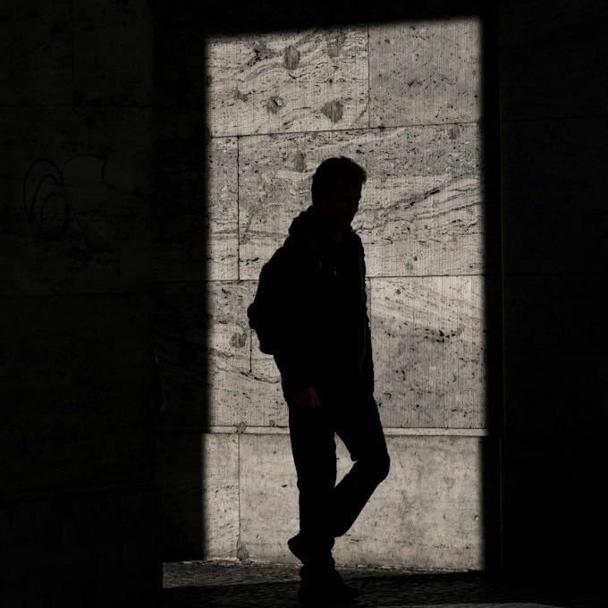 silhouette of man standing inside structure silhouette of man standing inside structure
