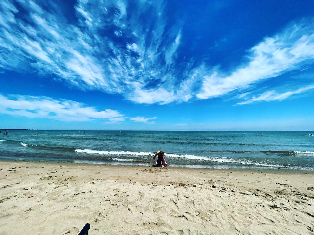 Boy digging in the sand on the beach.