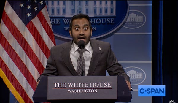 A man in a brown suit with an American flag behind him, standing at a lectern labeled “The White House.” His eyes are open extra wide.