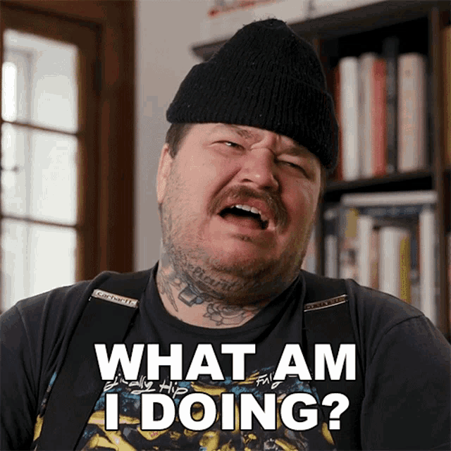 a man wearing a black hat and a black shirt says what am i doing