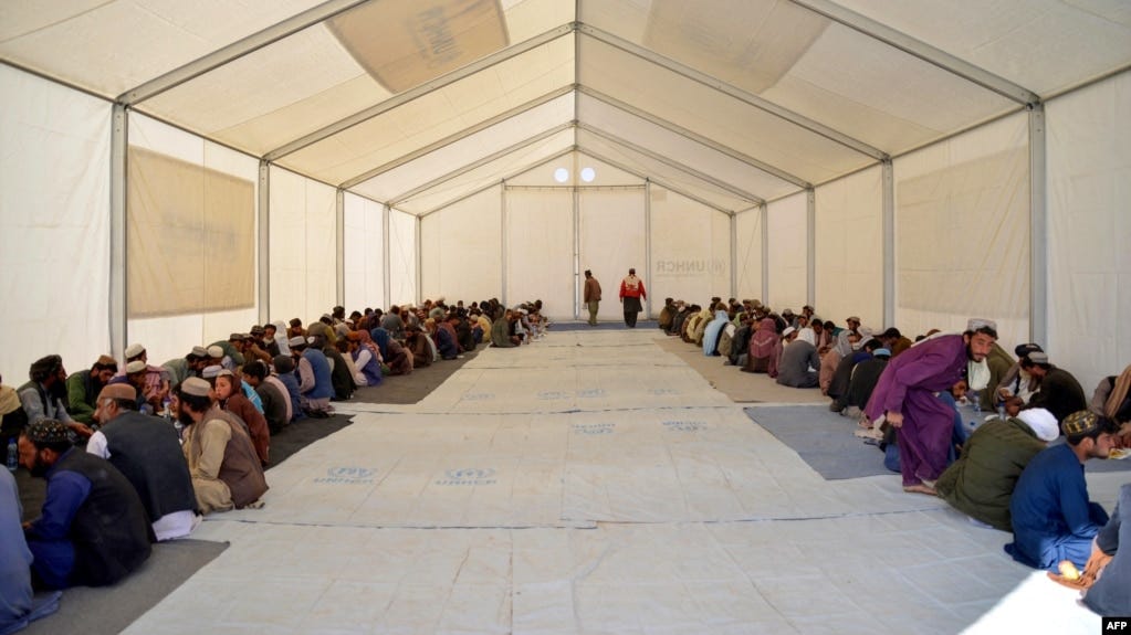 Afghan refugees eat lunch at a registration center upon their arrival from Pakistan at the Afghanistan-Pakistan border in Spin Boldak district of Kandahar province on Dec. 3, 2023.