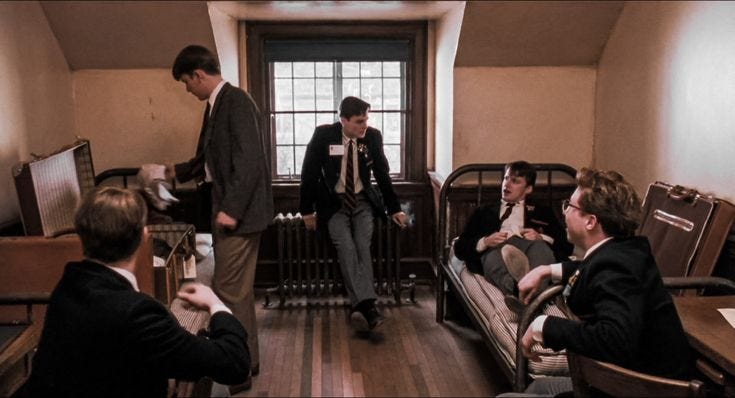 This may contain: several men in suits and ties sitting around a room with couches, tables and chairs