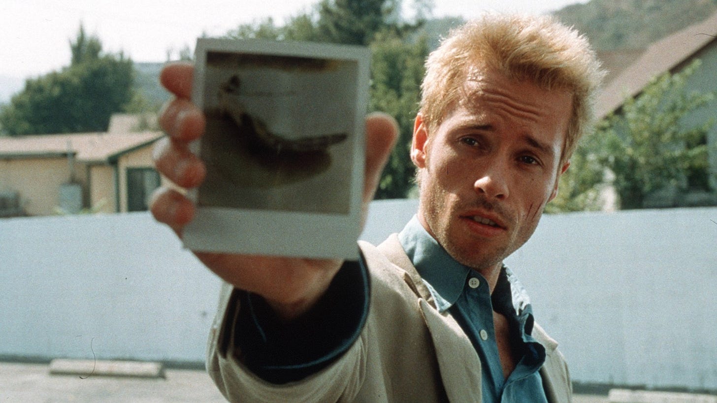 Memento | Still features Guy Pearce as Leonard Shelby holding a photograph.