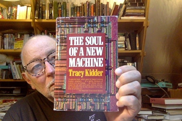 Photo of some old bald dude in a cluttered office holding a hardback copy of Tracy Kidders' "The Soul of a New Machine" Photo of some old bald dude in a cluttered office holding a hardback copy of Tracy Kidders' "The Soul of a New Machine"