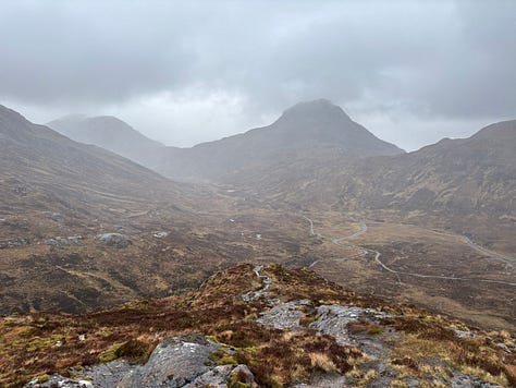 A local wood carving on the trail, a wet top, and a view of the Grey Corries