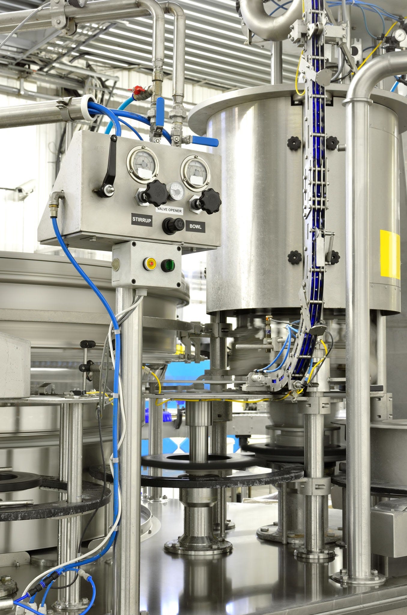 Image of shiny industrial equipment with pipes, wires and othe connections at the factory