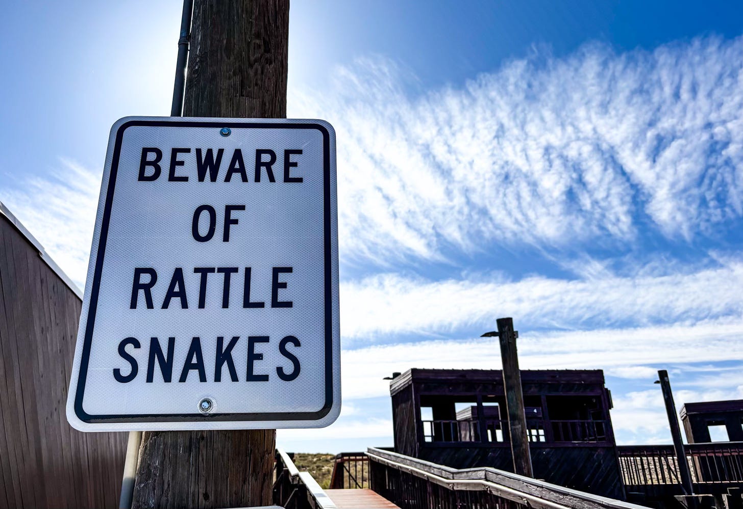 sign on post reading Beware of Rattlesnakes
