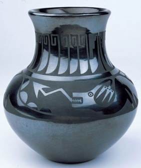 This may contain: a black vase sitting on top of a white table